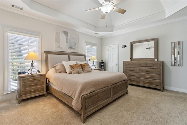 bedroom with a raised ceiling, visible vents, crown molding, and light carpet