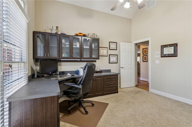 office space with a healthy amount of sunlight, light colored carpet, visible vents, and baseboards