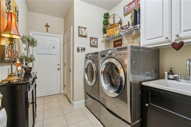 laundry area with light tile patterned floors, a sink, baseboards, cabinet space, and washing machine and clothes dryer