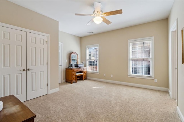 bedroom featuring light carpet, a closet, and baseboards