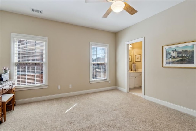 carpeted bedroom featuring ensuite bathroom, ceiling fan, visible vents, and baseboards