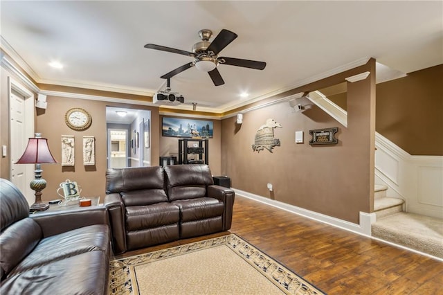 home theater with a ceiling fan, crown molding, baseboards, and wood finished floors