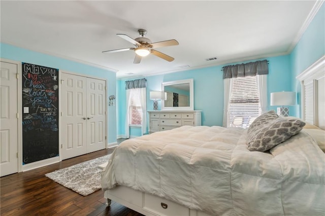 bedroom featuring ornamental molding, visible vents, baseboards, and wood finished floors