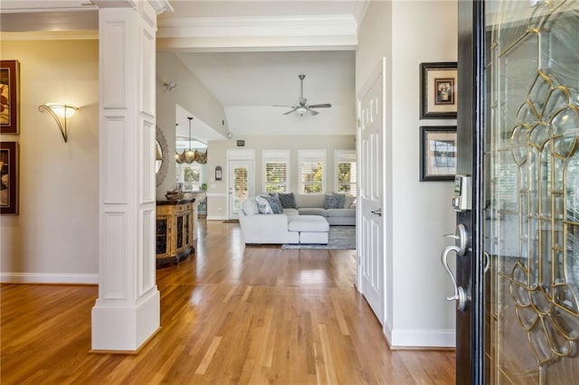 entrance foyer with crown molding, ceiling fan, light wood-style flooring, and ornate columns