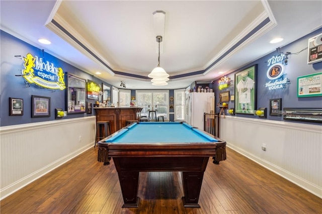 game room featuring a wainscoted wall, hardwood / wood-style floors, and a raised ceiling