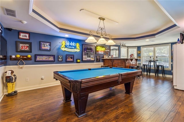 game room with ornamental molding, a raised ceiling, visible vents, and hardwood / wood-style flooring