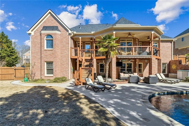 back of property with a patio, brick siding, a ceiling fan, stairway, and a gate