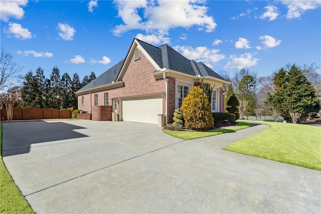 view of side of property with a garage, brick siding, fence, concrete driveway, and a lawn