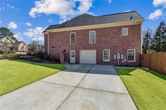 back of house with an attached garage, brick siding, fence, driveway, and a lawn