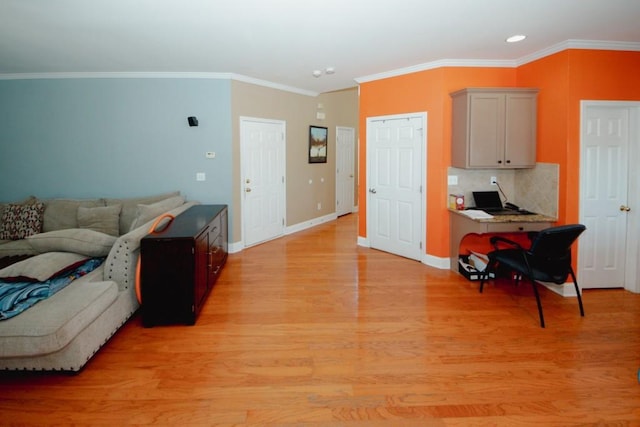 living area with baseboards, crown molding, and light wood-style floors