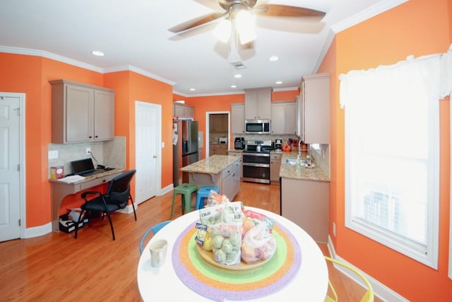 kitchen with light wood-style floors, ornamental molding, stainless steel appliances, and gray cabinetry