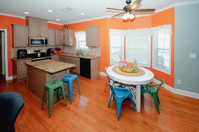 kitchen featuring appliances with stainless steel finishes, gray cabinets, a sink, and ornamental molding