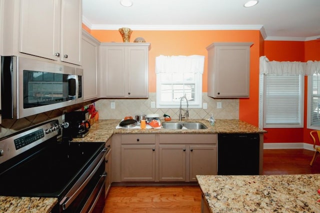 kitchen featuring a sink, light wood-style floors, ornamental molding, appliances with stainless steel finishes, and backsplash