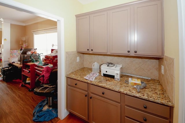 kitchen with ornamental molding, light stone countertops, decorative backsplash, and wood finished floors