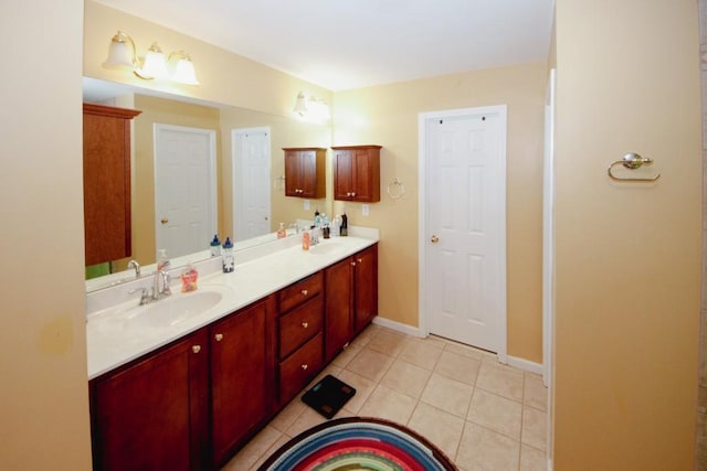 full bath with double vanity, tile patterned flooring, baseboards, and a sink