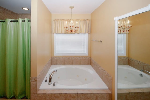 full bath featuring a jetted tub, an inviting chandelier, and a shower with curtain