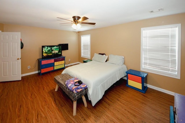 bedroom featuring baseboards, visible vents, ceiling fan, and wood finished floors