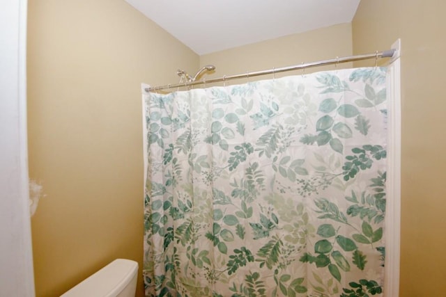 full bath with curtained shower and toilet