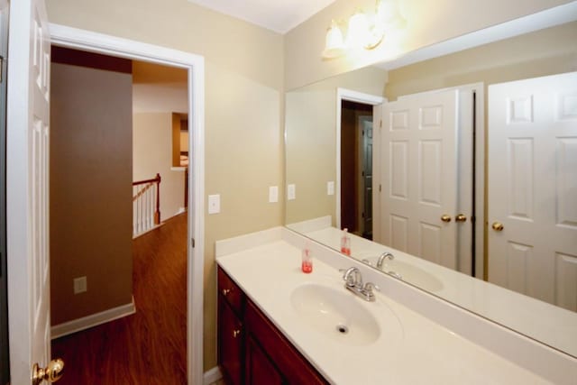 bathroom with baseboards, wood finished floors, and vanity