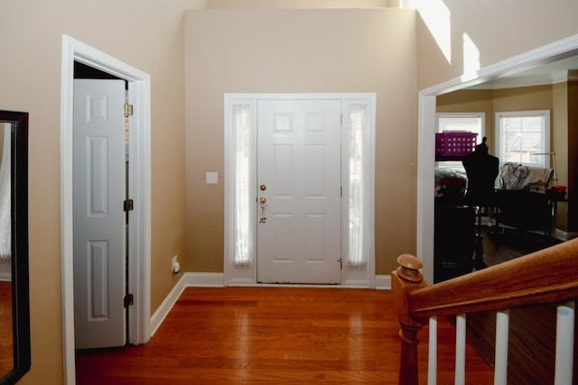 foyer entrance with baseboards and wood finished floors