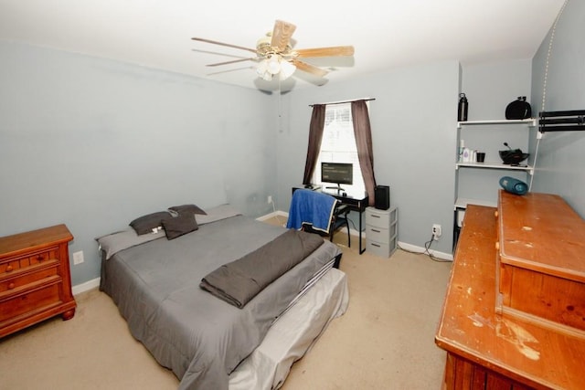 bedroom featuring light carpet, a ceiling fan, and baseboards