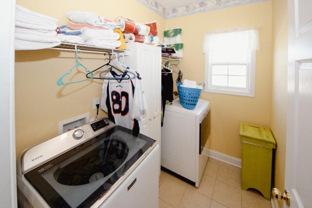 laundry room with light tile patterned floors, laundry area, independent washer and dryer, and baseboards