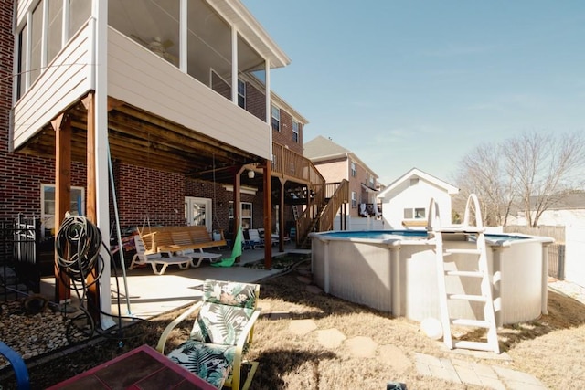 exterior space with an outdoor pool, brick siding, and a patio