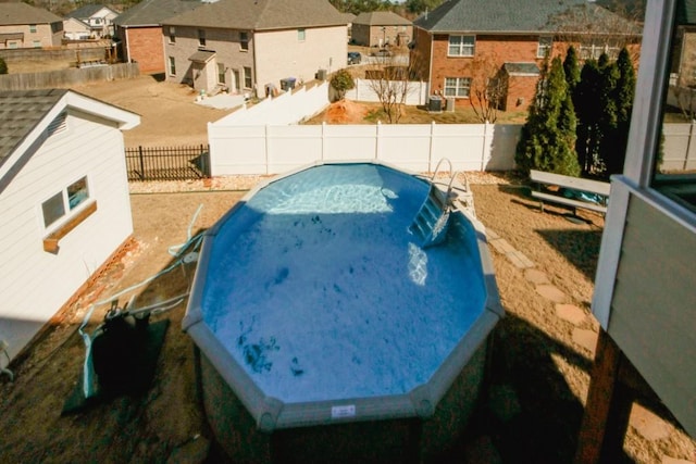 view of swimming pool featuring a fenced backyard, a residential view, and area for grilling