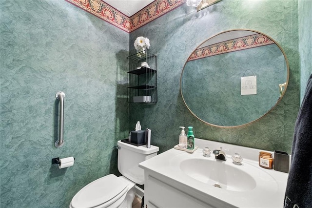 half bath featuring toilet, wallpapered walls, and vanity