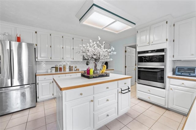 kitchen featuring white cabinets, light tile patterned floors, stainless steel appliances, and light countertops