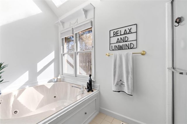 bathroom with baseboards, a jetted tub, and tile patterned floors