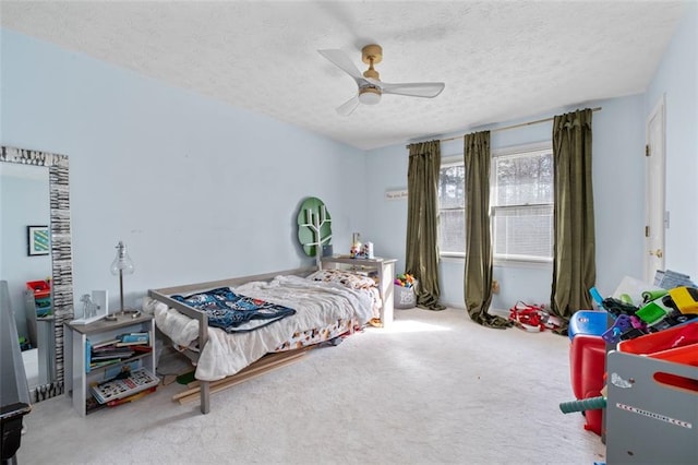 carpeted bedroom featuring a ceiling fan and a textured ceiling