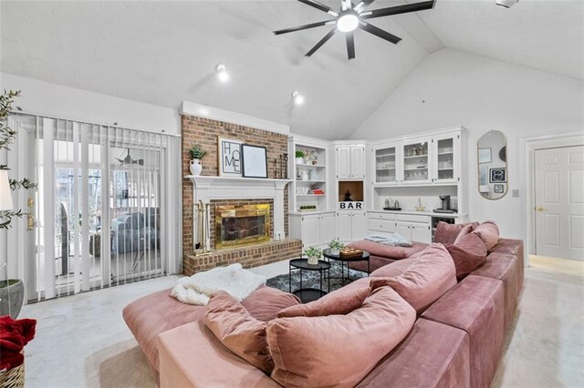 living area with a brick fireplace, ceiling fan, and high vaulted ceiling