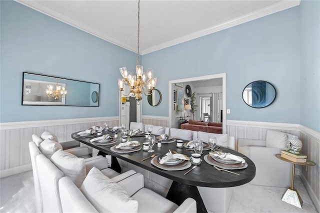 dining space featuring a chandelier, wainscoting, and crown molding