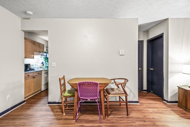 dining space with wood-type flooring and a textured ceiling