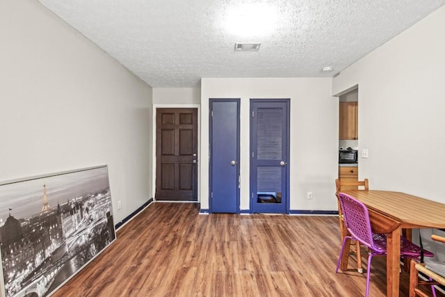 interior space with dark wood-type flooring and a textured ceiling