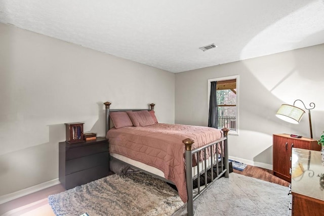 bedroom with a textured ceiling and light wood-type flooring