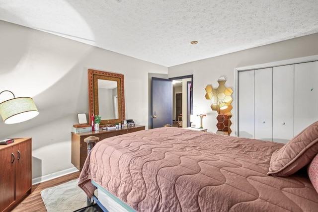 bedroom with hardwood / wood-style flooring, a closet, and a textured ceiling