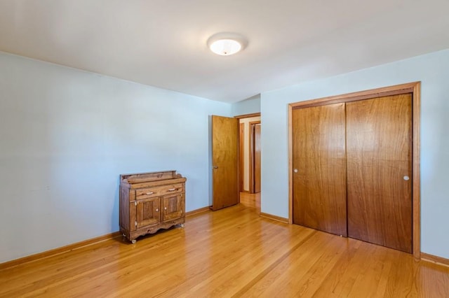 unfurnished bedroom with light hardwood / wood-style flooring and a closet