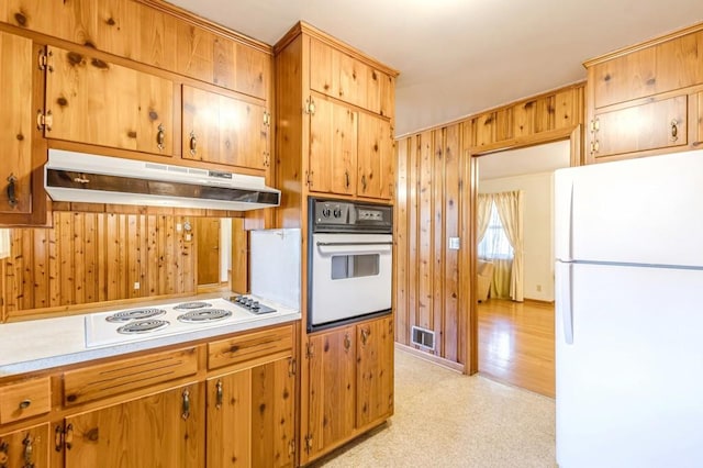 kitchen featuring white appliances and wooden walls