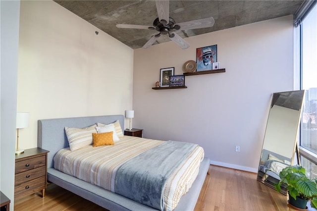 bedroom featuring wood finished floors, baseboards, and ceiling fan