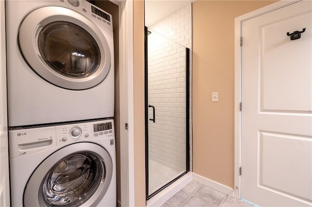 laundry area featuring light tile patterned floors, laundry area, and stacked washer and clothes dryer