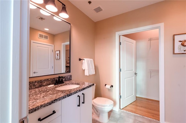 bathroom with visible vents, toilet, and vanity