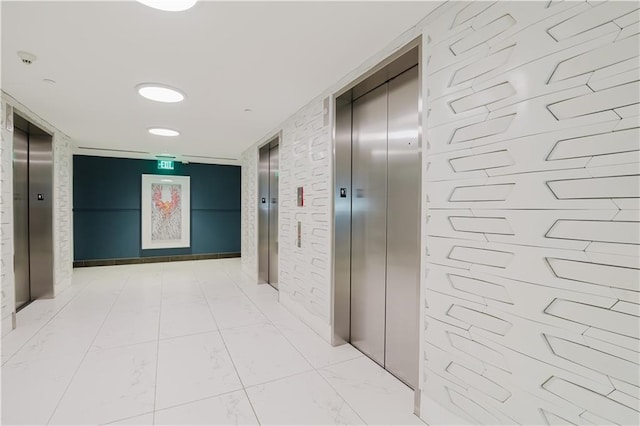 hallway with elevator and marble finish floor