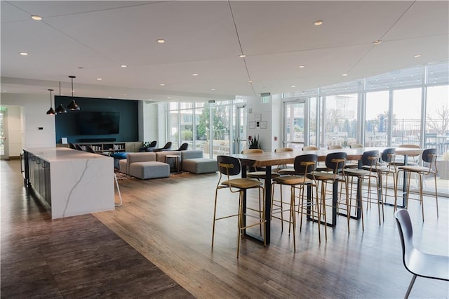 dining space with recessed lighting, floor to ceiling windows, and wood finished floors