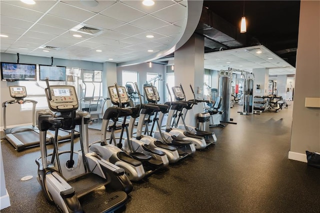 exercise room featuring a drop ceiling, visible vents, and baseboards