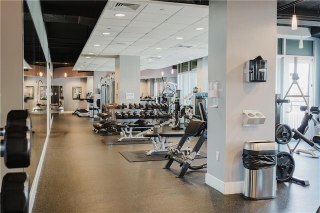 gym featuring visible vents, baseboards, and a drop ceiling