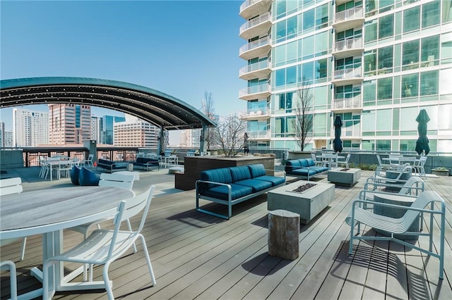 wooden deck featuring a city view and an outdoor living space with a fire pit