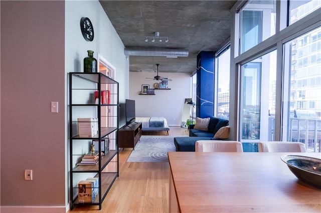 dining area with a healthy amount of sunlight, baseboards, a ceiling fan, and wood finished floors