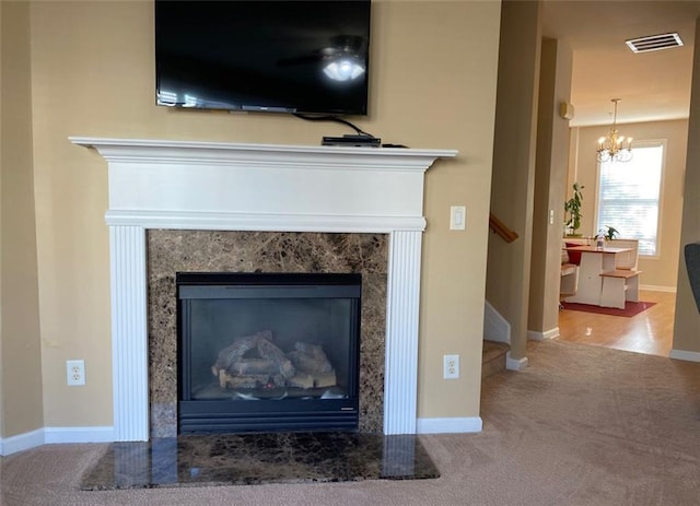 details with a fireplace, carpet floors, and an inviting chandelier